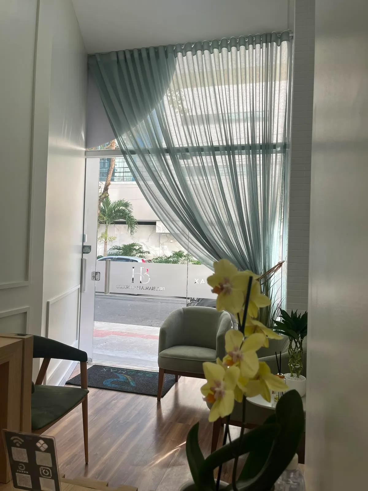 Recepção da Clínica Bianca Horongozo, com poltronas e orquídea