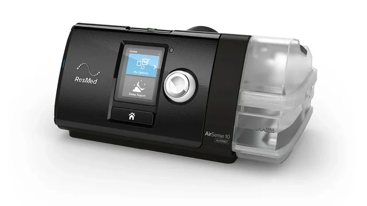 Aparelho de CPAP ResMed AirSense 10 AutoSet com a câmara de água do umidificador acoplada, visto de três quartos